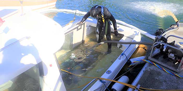 Diver coming onboard a boat that has let in water